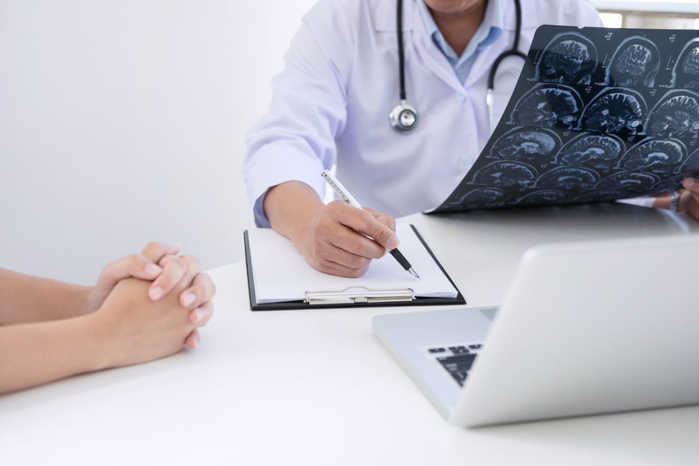 doctor looking at CT scans and talking to a patient